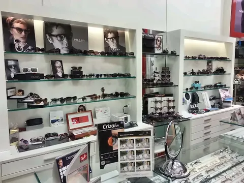 Prateleiras com óculos Prada, Tom Ford e outras marcas ao lado do balcão de atendimento